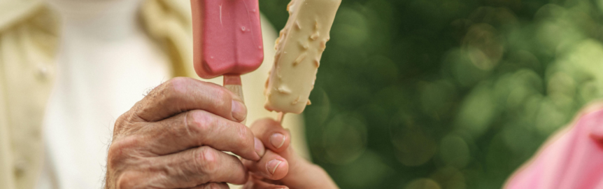 two people "toasting" with two different popsicles, to illustrate the concept of 'split interests'